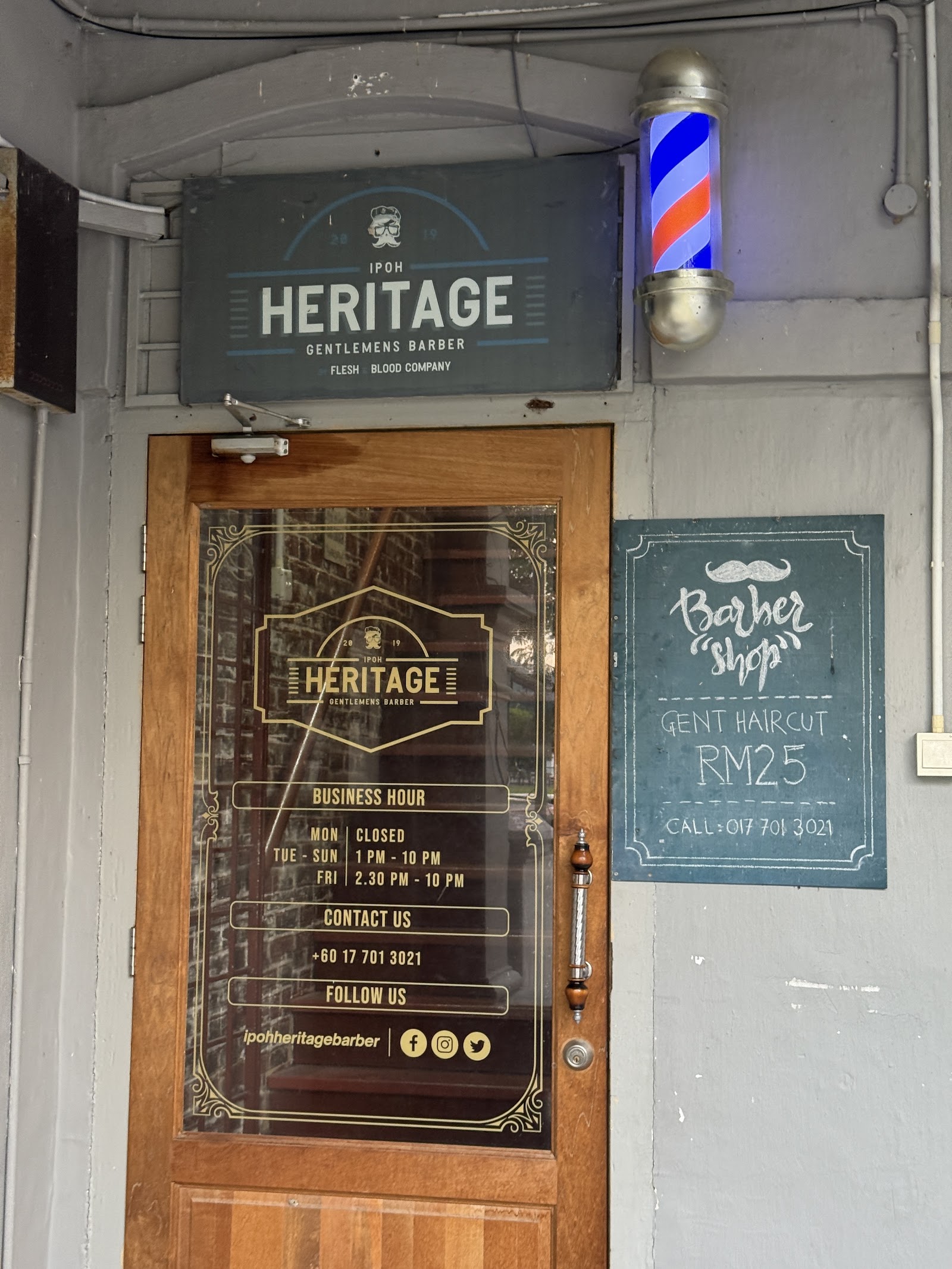 Shop entrance signage with business hours and contact details at Ipoh Heritage Barber Shop